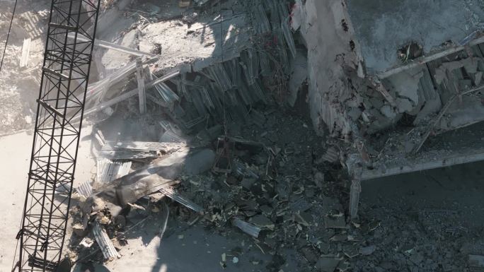 挖掘机在拆迁现场清理垃圾。无人机拍摄的被毁建筑全景。