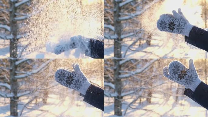 冬季公园里，戴着连指手套的女性拍手，玩雪。特写，超级慢镜头。在夕阳和阳光的映衬下，雪花飞扬。在阳光明