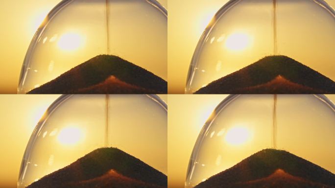 沙漏概念在模糊背景的金色太阳圆盘天空在日落光线在夏季特写。金沙倒得快。时间概念沙。放松