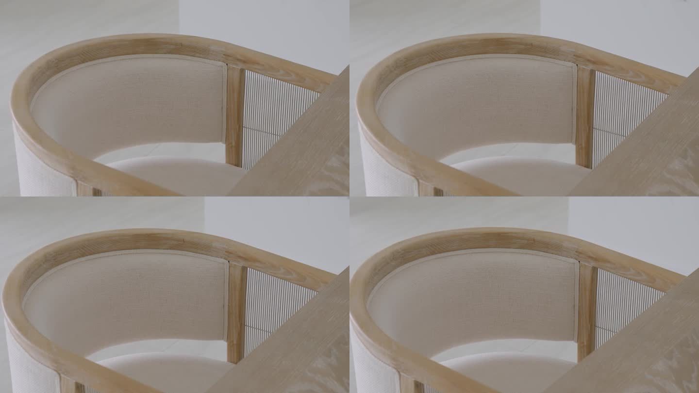 Сlose现代椅子的上视图，靠近桌子的木框，浅色布料的内部坐垫和圆形靠背
