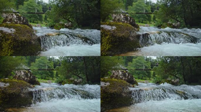 SLO莫多利拍摄田园诗般的溪流流过苔藓岩石与桥的背景在森林白天