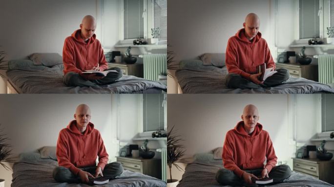 在床上看书，在暗室里看相机的光头男患癌症