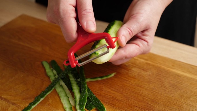 新鲜的黄瓜被切成小块用于烹饪。做黄瓜菜。缓慢的运动。