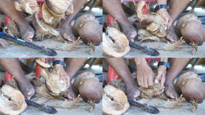 亚洲人用腿和工具剥椰子。