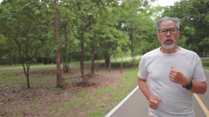 一位亚洲老人在公园户外跑步慢跑