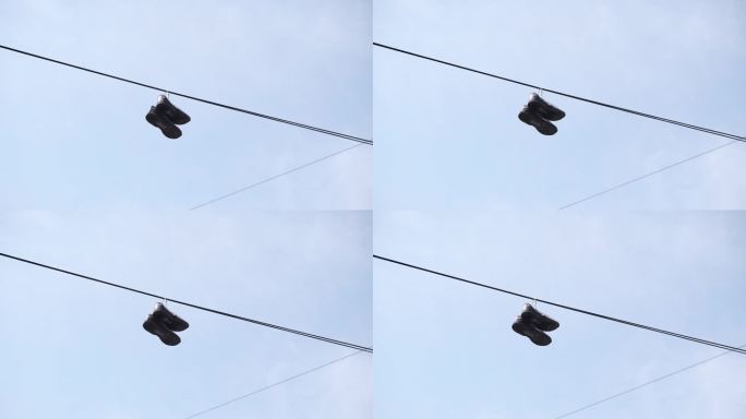 一双旧鞋挂在电线上，对着天空。标志着这个地区的毒品走私。