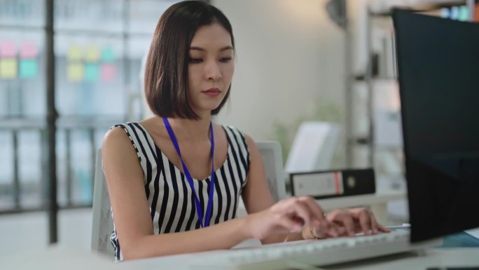 专注和专注的工作与亚洲女性专注于她的工作任务，在办公室专业，专注和富有成效的工作环境，使其成为一个理
