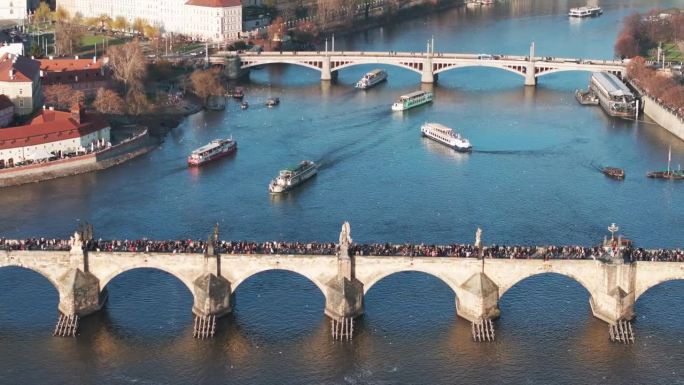 从空中俯瞰查理大桥，河上漂浮着多艘游船