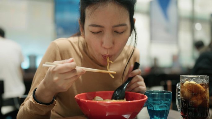 亚洲女游客在日本餐厅吃日本荞麦面。