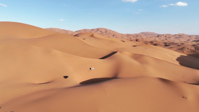航拍新疆沙漠沙丘无人区里自驾行驶的汽车