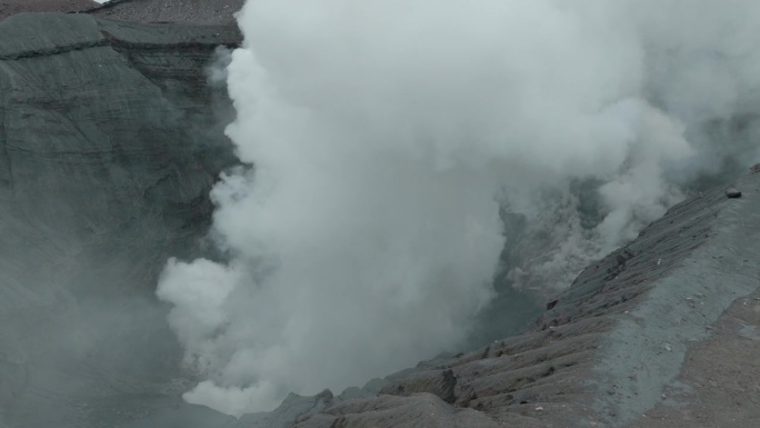 日本阿苏山鸟瞰图，捕捉火山冒出的烟雾，由无人机拍摄，达到电影效果