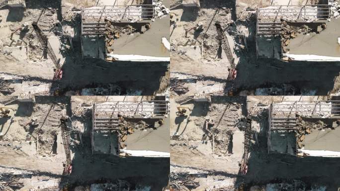 无人机拍摄的被毁建筑物。拆除建筑物。挖掘机在拆迁现场清理垃圾。自顶向下镜头
