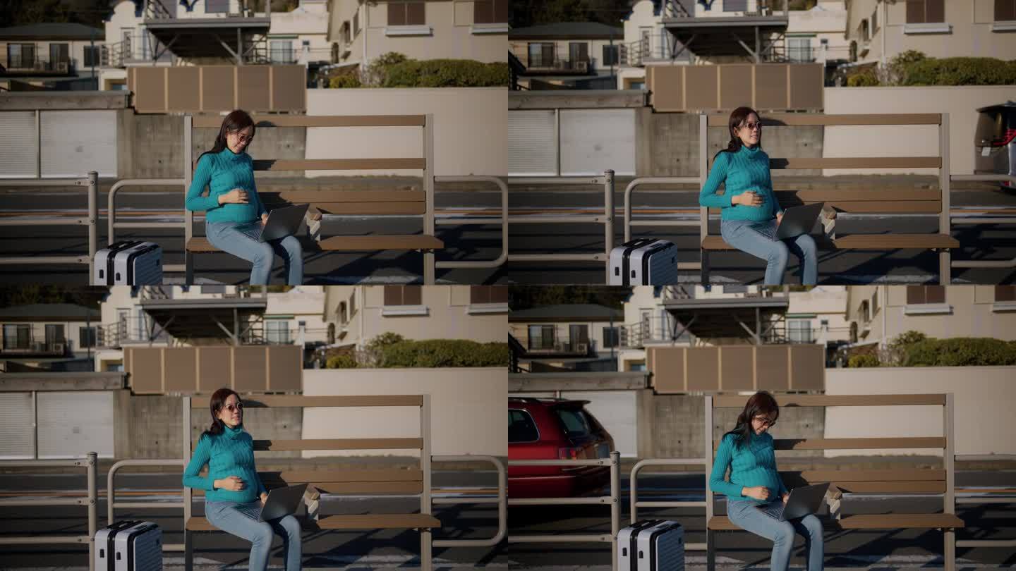 一个孕妇在户外用笔记本电脑工作的前视图