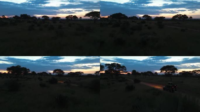 无人机在稀树草原上空低空飞行，一辆越野车在非洲的一条土路上行驶
