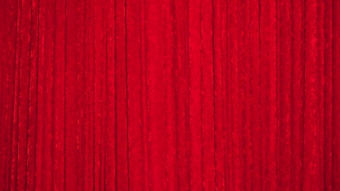 用红色长毛绒织物制成的覆盖舞台的幕布。织物颜色呈红色，布料有质感，纺织背景