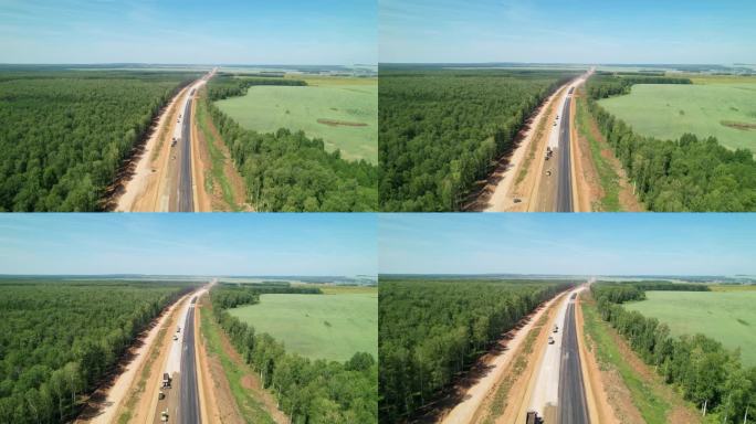 新建高速公路的鸟瞰图。为了修路而砍伐森林。这条在建的路一直延伸到远处。