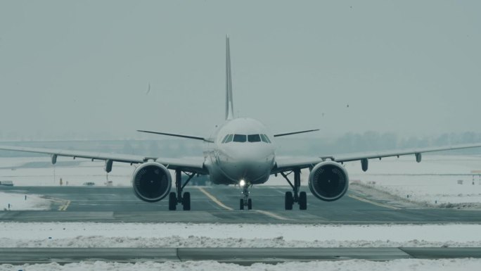 在下雪的机场，A320NEO客机向右滑行
