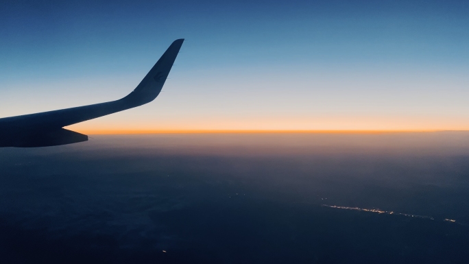 透过飞机窗户看窗外夕阳天空日出日落傍晚