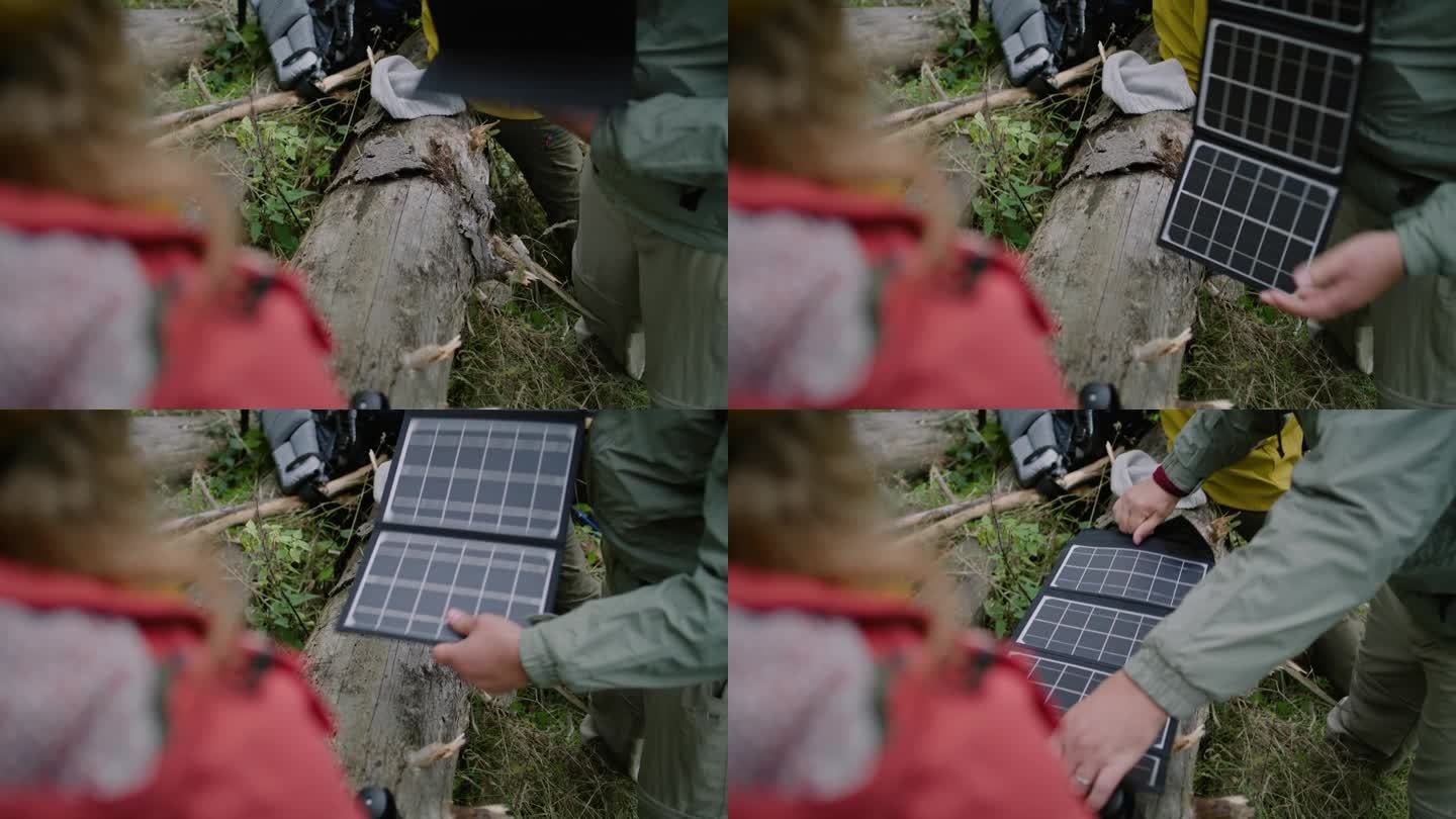 游客在原木上放置太阳能电池板，为设备充电