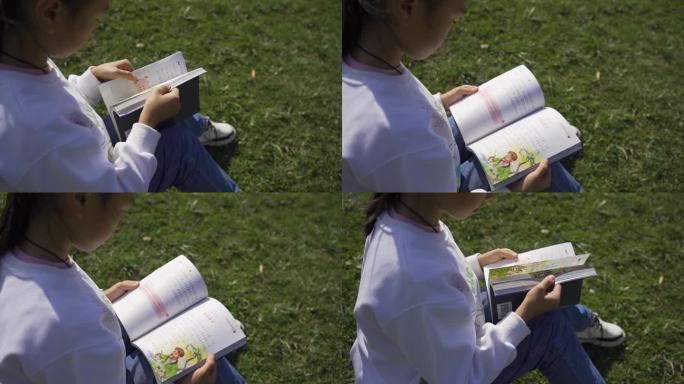 手翻书 特写 坐在草地小孩野外看书