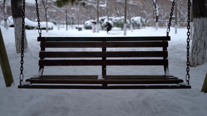 冬天下大雪时在公园里荡秋千