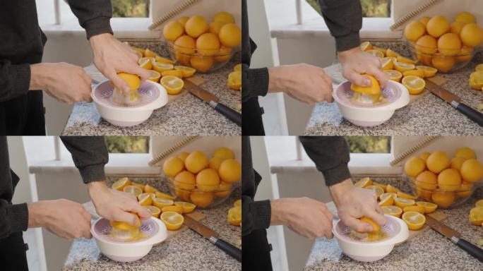 桌上有一堆橘子，一个男人用手从橘子里挤出新鲜的果汁。