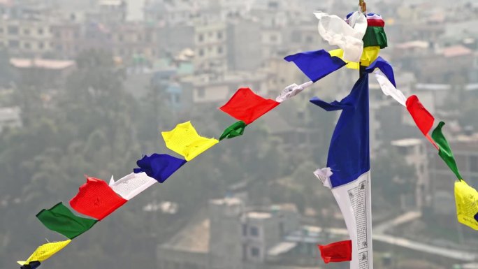 五颜六色的西藏经幡在加德满都上空的清风中飘扬着古老的祷文