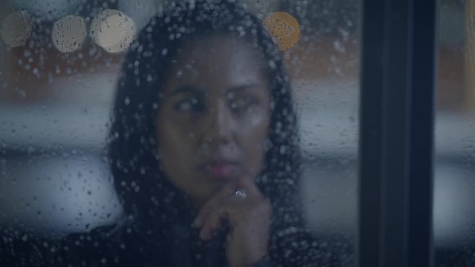 有思想的年轻女子在雨中思考夜晚的生活