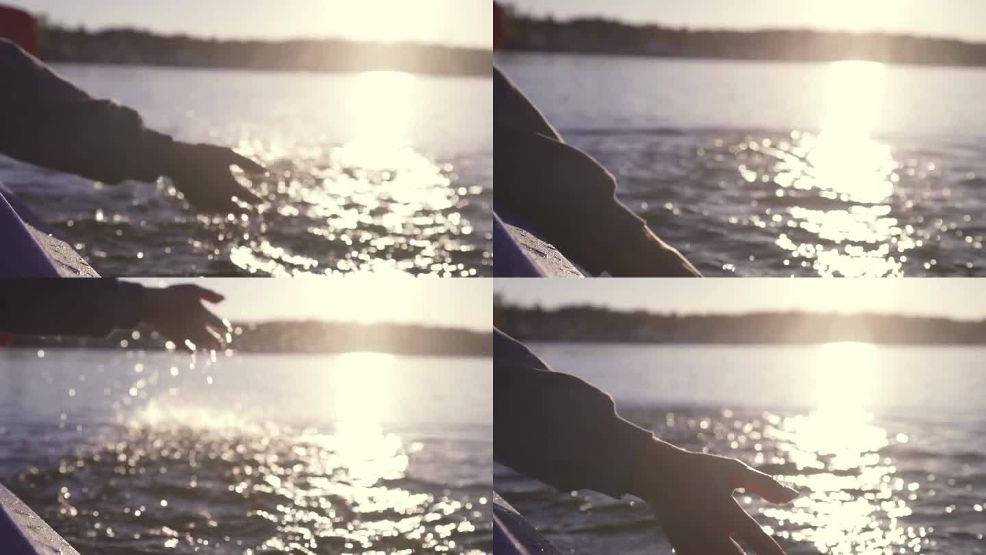 在平静的水面上划桨，在夕阳的背景下，在皮划艇上进行户外活动，水上运动