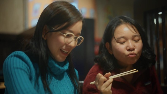 两名年轻女子在度假期间在餐厅享受日式烧烤。