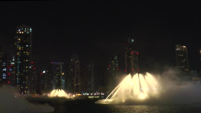 迪拜喷泉水上表演的美景在晚上跳舞喷泉。哈利法塔附近的迪拜购物中心里的镭射灯。