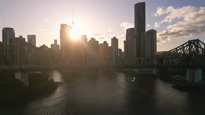 日落时分，澳大利亚昆士兰州布里斯班，布里斯班故事桥上拥挤的交通和现代办公大楼的4K鸟瞰图实时镜头