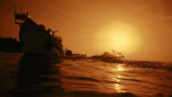 日落时分一对游客从船上跳入大海的剪影