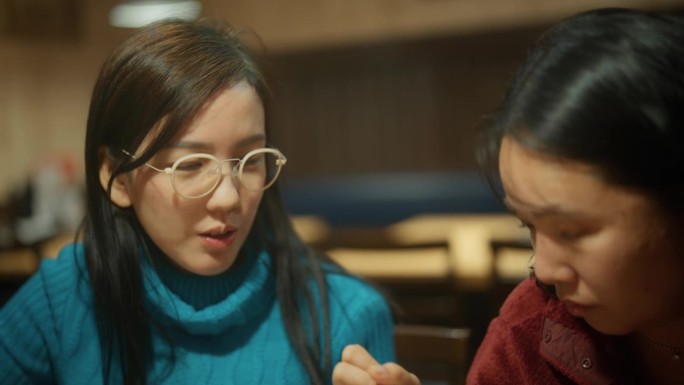 在日本餐厅吃饭时，表情严肃的亚洲女商人正在交谈