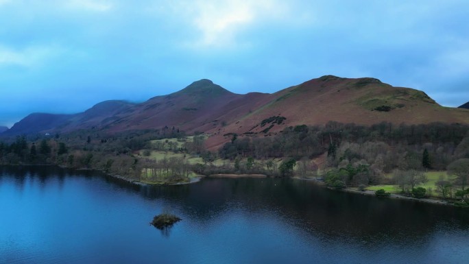 英格兰Keswick Derentwater湖区。无人机在湖上飞行，视野中的莱克兰山脉。风景优美的电