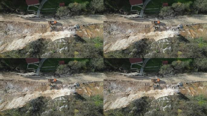 山体滑坡摧毁当地道路后，挖掘机正在清理多余的土壤