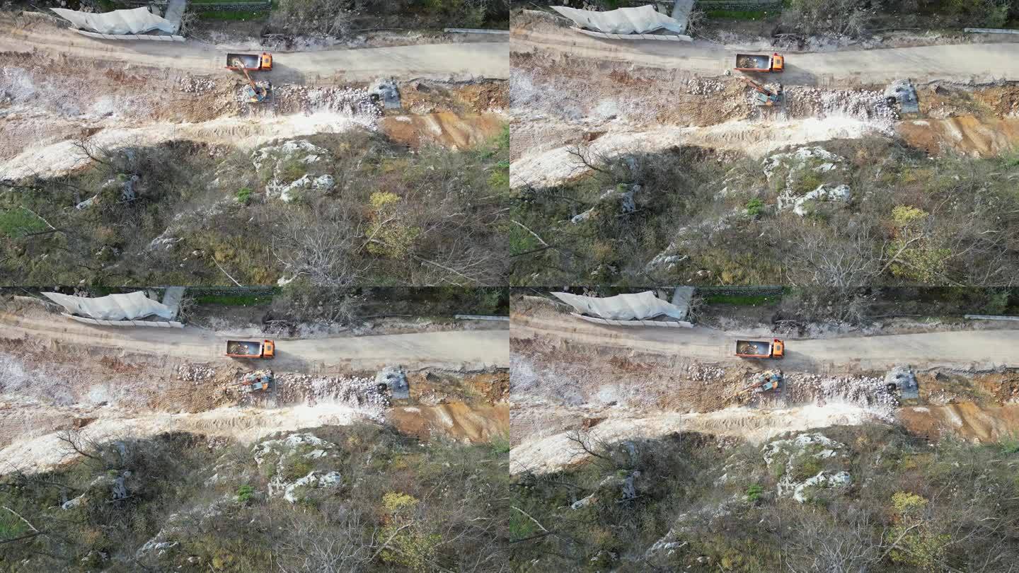 放大无人机拍摄的滑坡后，挖掘机将泥土和碎石装上卡车进行清理的画面