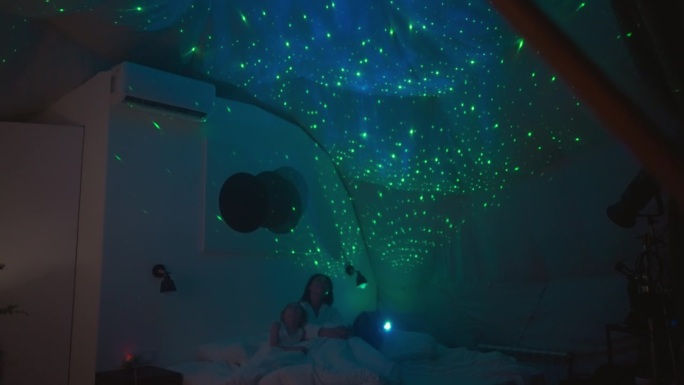 一家人看着投影仪投射在天花板上的星空