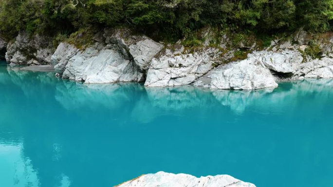 岩石映照在霍基蒂卡峡谷清澈的海水中，令人着迷地展示了大自然的倒影。