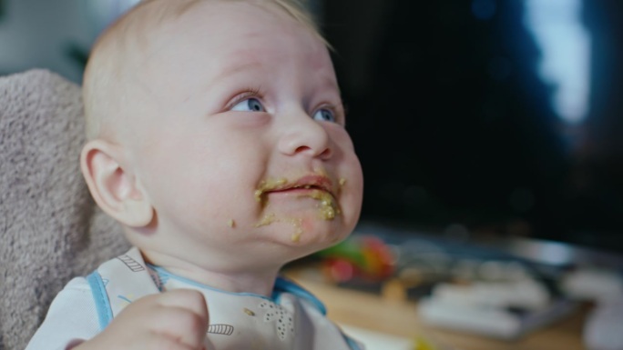 母亲给婴儿喂食的小手。介绍固体食物