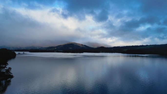 英格兰Keswick Derentwater湖区。无人机在湖上飞行，视野中的莱克兰山脉。风景优美的电