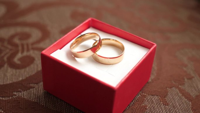 红盒子里的金结婚戒指。婚礼仪式。