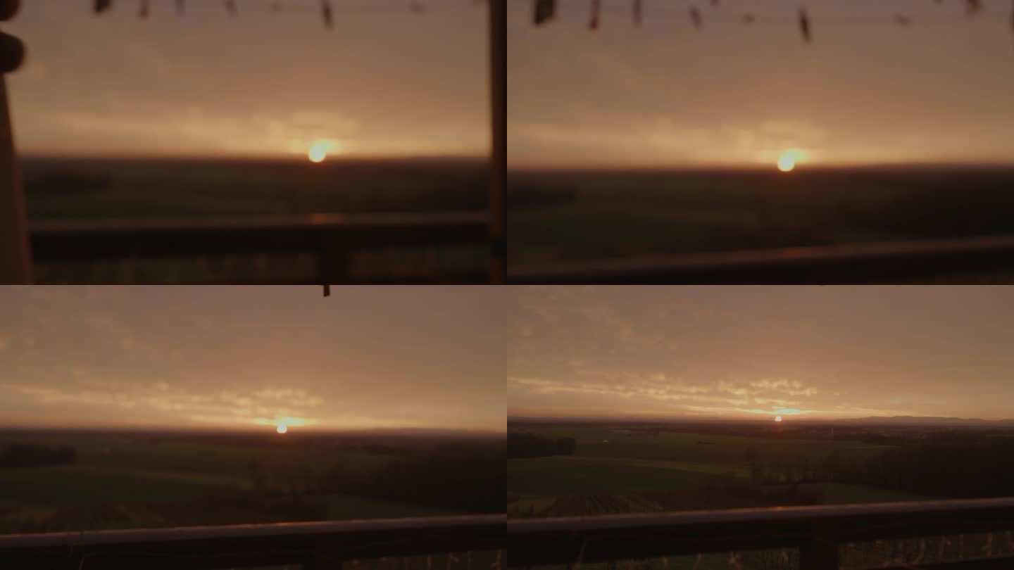 日落时分，一个不知名的人的手滑过窗帘，透过窗户欣赏美丽的绿色风景