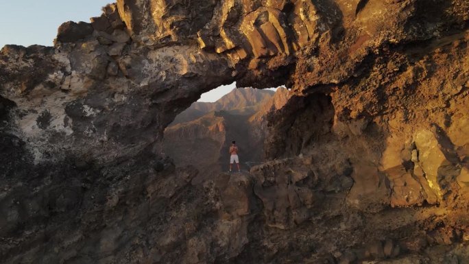 “多丽变焦”效果在航拍视频的los Gigantes洞。太阳把金色的光芒洒在山峰和山谷上。