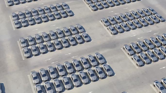 一个巨大的汽车经销商停车场上的新型电动跑车鸟瞰图。多排自动驾驶汽车准备进出口业务。储存待售的新车。逼