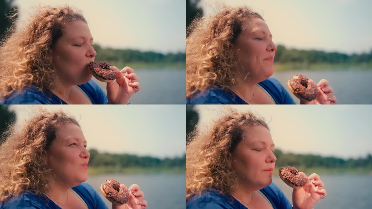 大码女人在公园吃甜甜圈的特写，暴食的问题