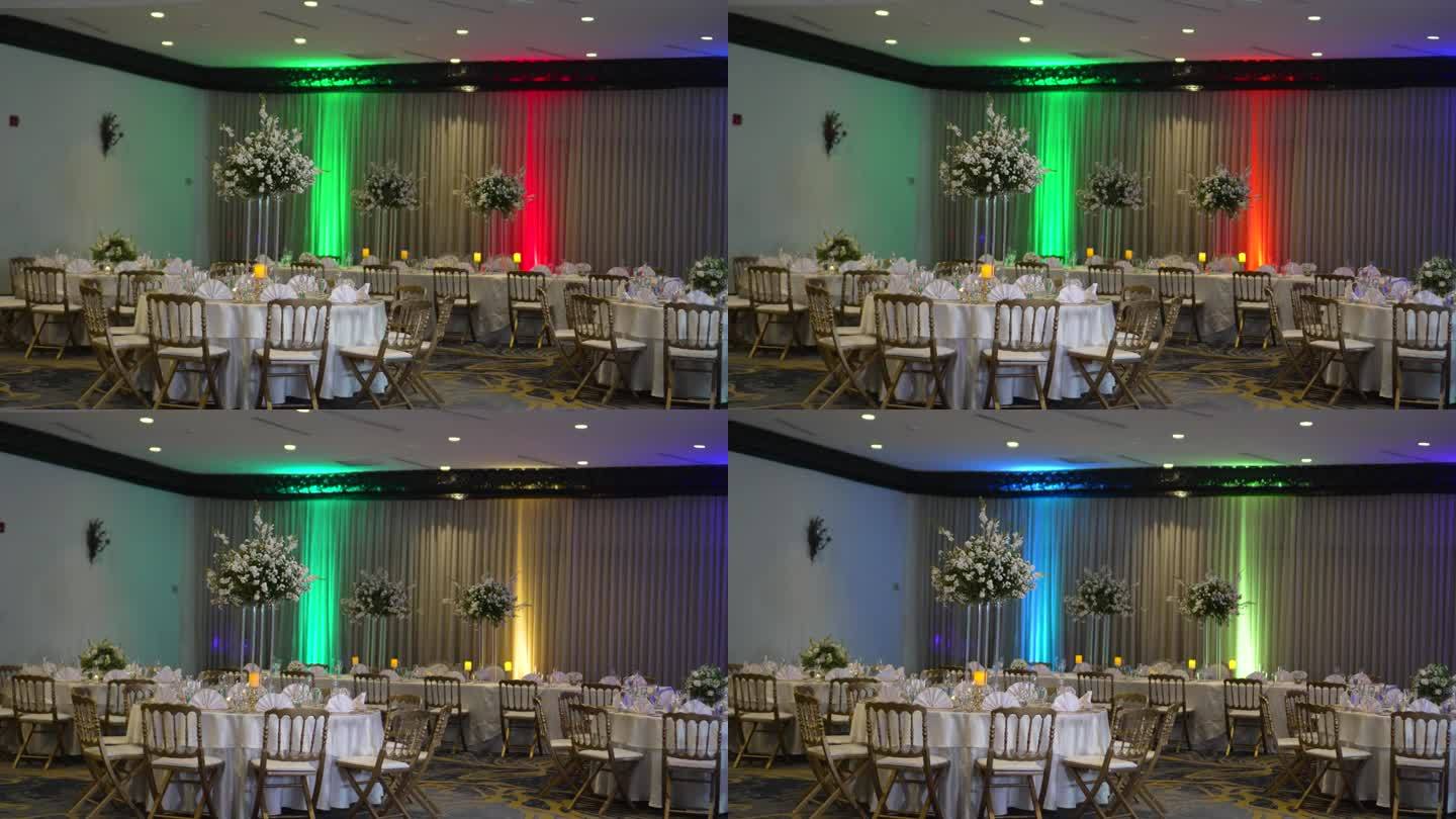 酒店的会议室，色彩缤纷，优雅，为婚宴庆典而装饰，圆桌上高高的中心装饰品，花和白玫瑰。