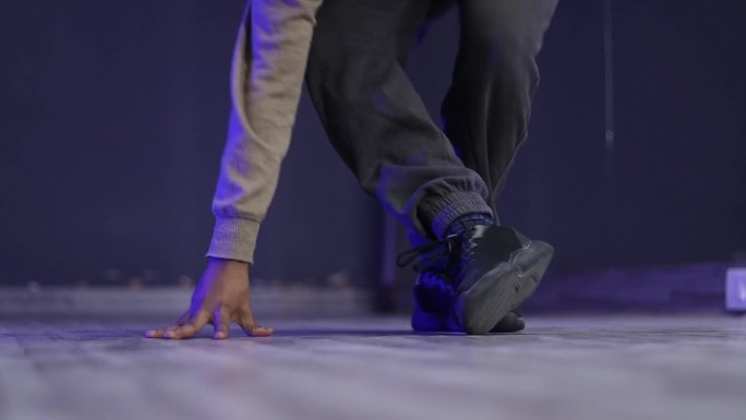 一名印度嘻哈舞者在练习步法或跳舞时脚踝扭伤或扭伤，然后重新站起来