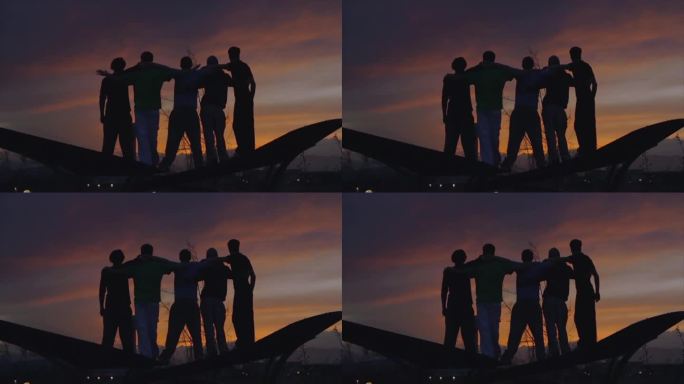 夕阳西下，五个人肩并肩站在田野里的剪影