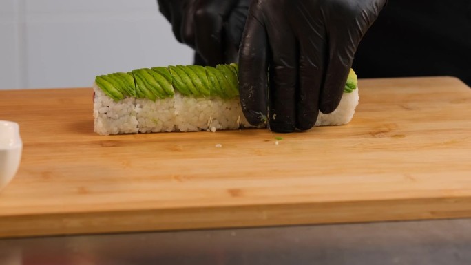 厨师用鳄梨切寿司卷。制作寿司的过程。